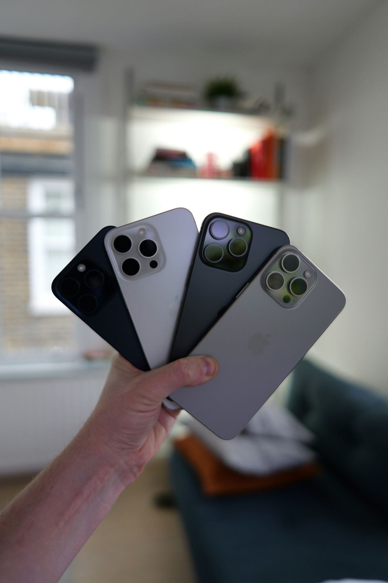 A person holding three cell phones in their hands